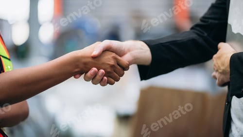 Preview: Team engineers and foreman stack hand and shake hands to show success at factory machines.