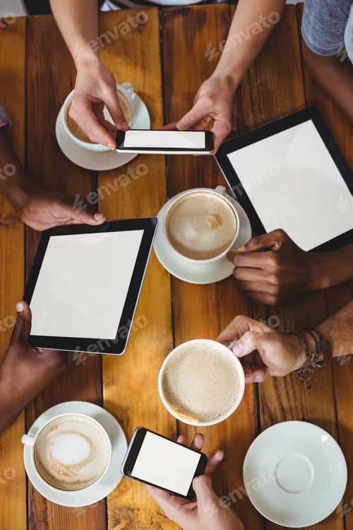 Preview: Group Of Friends Using Mobile Phone While Having Cup Of Coffee In Cafe
