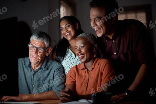 Preview: Shot of a group of businesspeople working on a computer in an office at night
