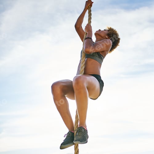 Preview: athletic african american woman climbing ropes