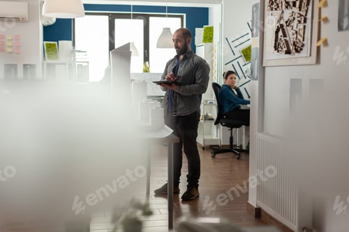 Visualização: Visão ampla do engenheiro de arquitetura segurando tablet olhando à distância