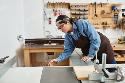 Preview: Young woman engaged in hands on woodworking at a creative workshop full of tools and inspiration