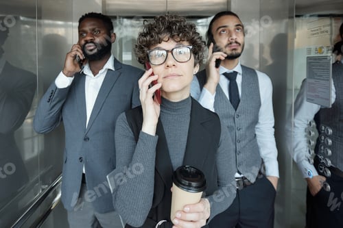 Preview: Pretty young businesswoman and her two intercultural colleagues with smartphones
