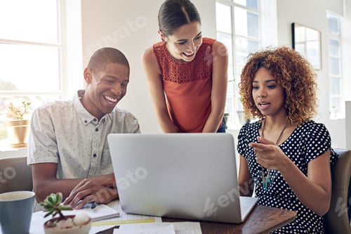 Preview: Shot of a group of colleagues working together on a laptop in an office