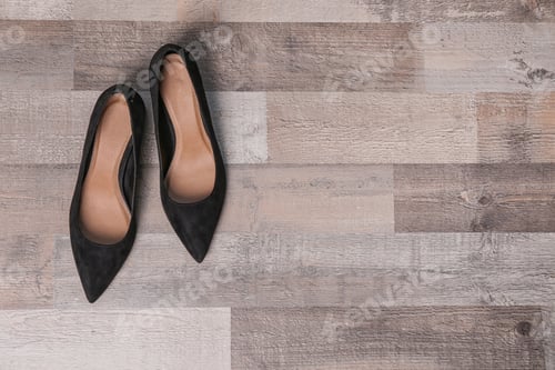 Preview: Pair of female shoes on wooden background, top view