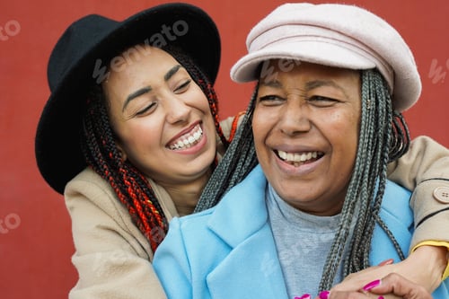 Preview: Happy african mother and daughter hugging each other in the city during autumn season