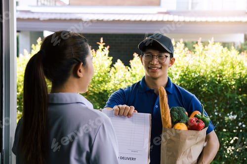 Preview: Supermarket food delivery staff deliver bags to female customers in front of the house.