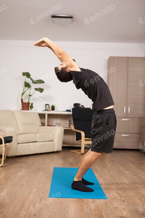 Preview: Attractive man with beard doing back stretch standing up