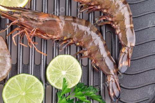 Vista previa: Raw shrimps on pan with lemon.