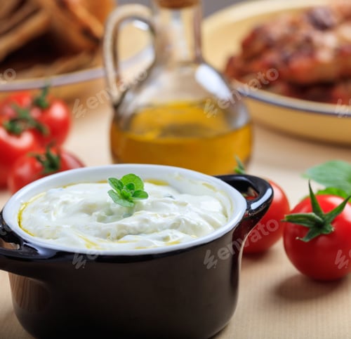 Preview: Traditional tzatziki sause in a black bowl on a table
