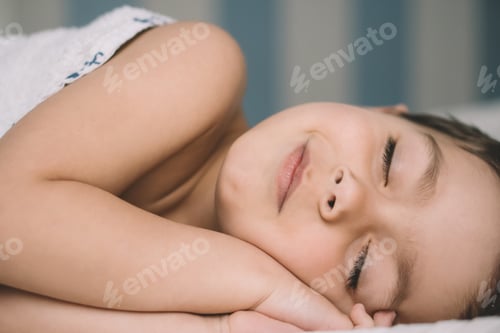 Preview: adorable boy smiling while slipping in bed