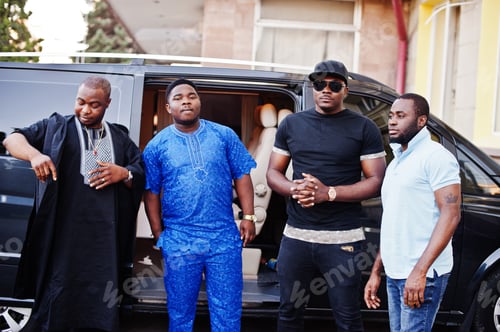 Preview: Black men wearing cool traditional clothes stand by the minivan.