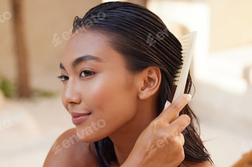 Preview: Woman Combs Shiny Dark Hair in Natural Light