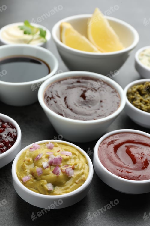 Preview: Different tasty sauces in bowls on grey table