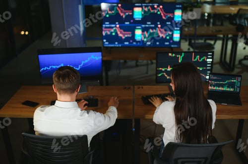 Preview: Team of traders working at monitor computer and browsing online in trading office