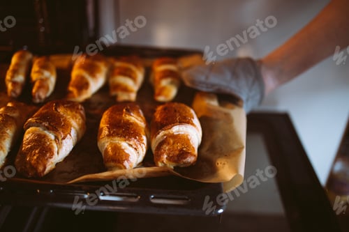 Preview: Close-up of delicious mouth-watering hot croissants on a baking sheet from the oven