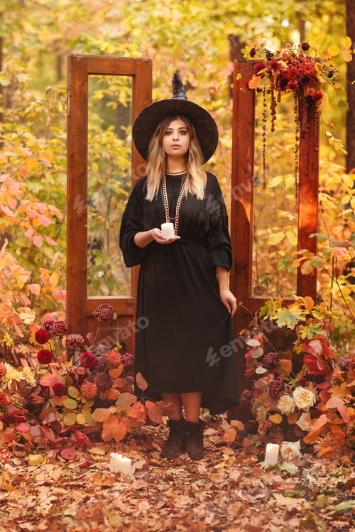 Preview: Witch costume and hat looking mysteriously at candle in her hands