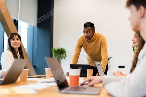 Preview: Black male team leader at business meeting in an office, discussing business affairs