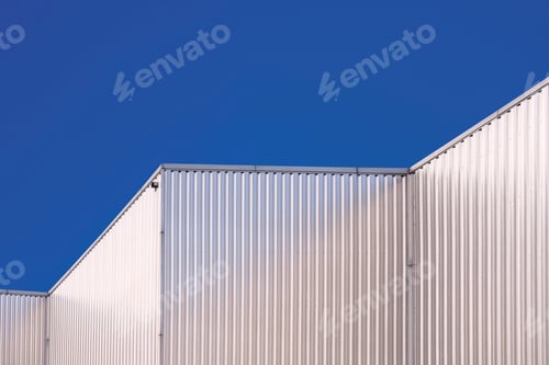 Preview: Aluminum corrugated industrial building against blue clear sky background