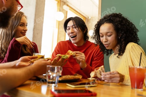 Preview: Happy friends eating pizza at restaurant