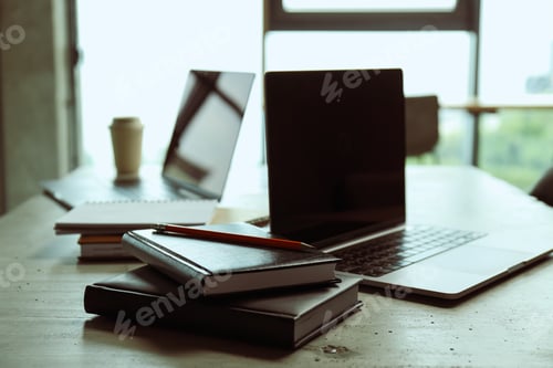 Preview: A laptop with documents, notebooks and a cup of coffee on the table