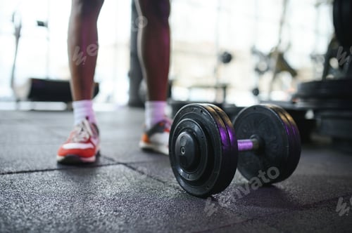 Preview: Close-up of a man takes a dumbbell in the gym