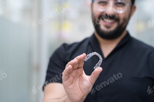 Preview: Positive dentist demonstrating clear aligners used for teeth straightening in stomatology center