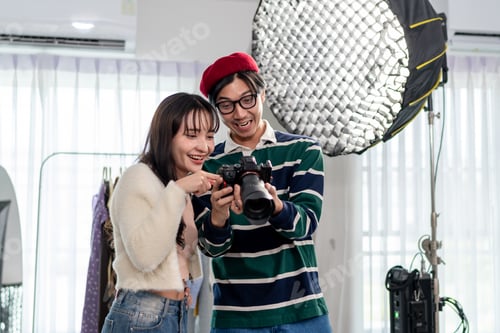 Preview: Asian beautiful woman model and cameraman working in photography studio.
