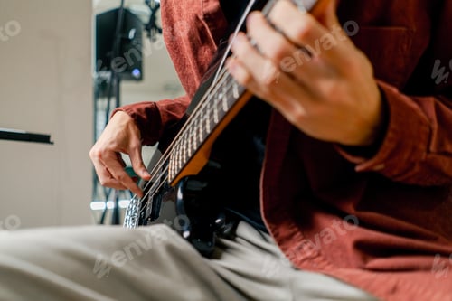 Preview: musician with electric guitar in recording studio plays musical instrument presses fingers strings
