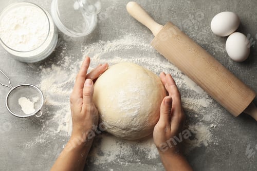 Preview: Female hands hold dough on gray background with ingredients for baking