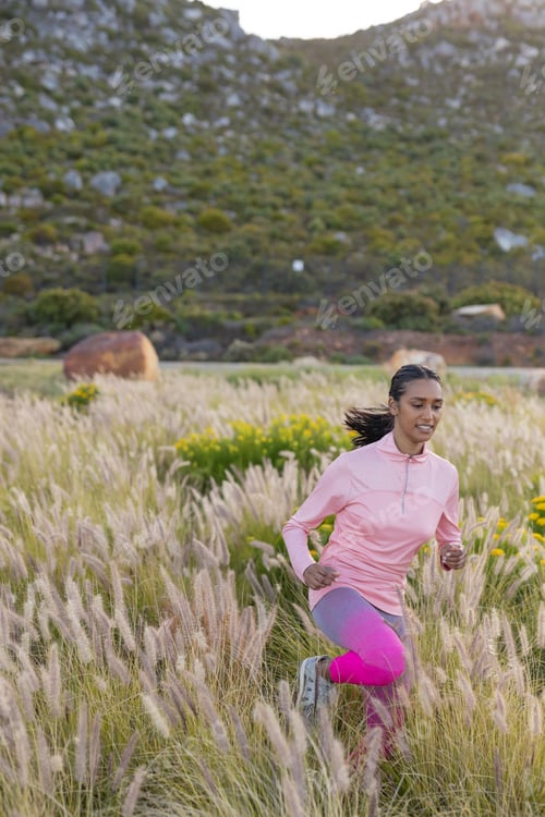 Preview: Woman running through grassy field, enjoying outdoor fitness in nature, copy space