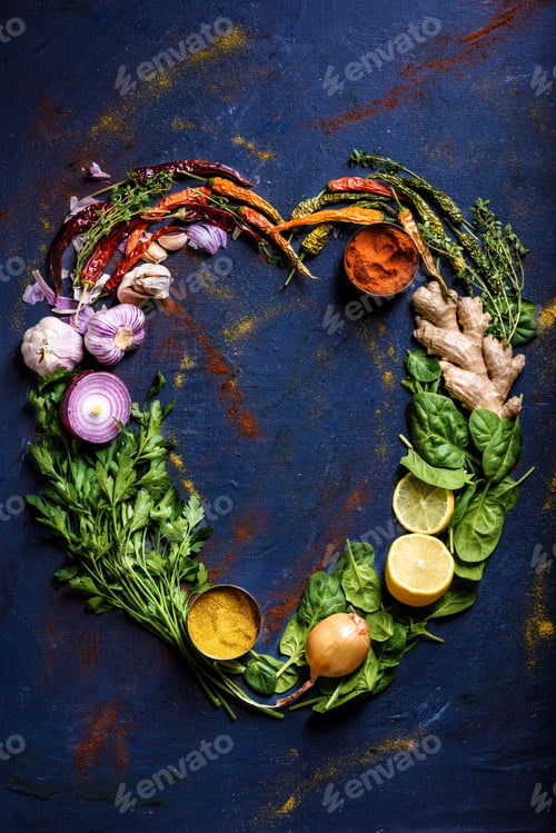 Preview: top view of heart made from herbs, vegetables and spices on blue