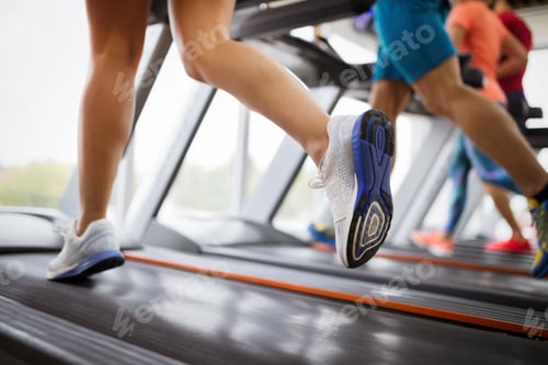 Preview: Healthy man and woman running on a treadmill in a gym