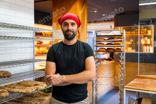 Preview: Corporate portrait of bakery manager in artisan bakery workshop, arms folded
