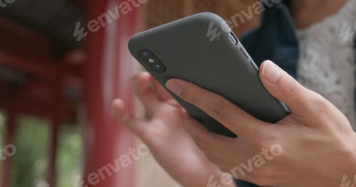 Preview: Woman work on smart phone in Chinese garden