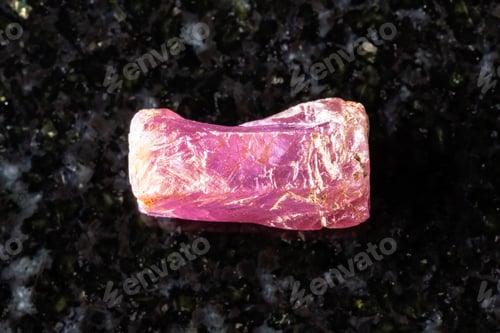 Preview: sample of rough pink ruby crystal on black granite