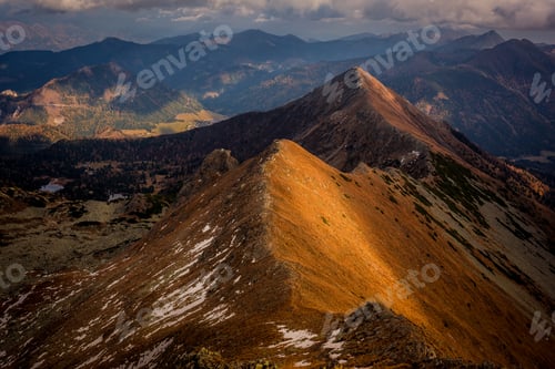 Preview: Mountain landscape in Austria, the sun is reflecting and coloring the mountain in yellow