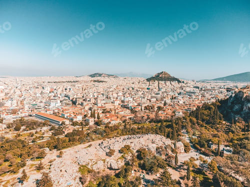 Preview: the city of athens from above with hills and trees in the foreground