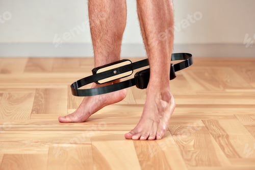 Preview: Close-up of a man's legs in the gym for pilates training with a spring reformer, pilates exercise to