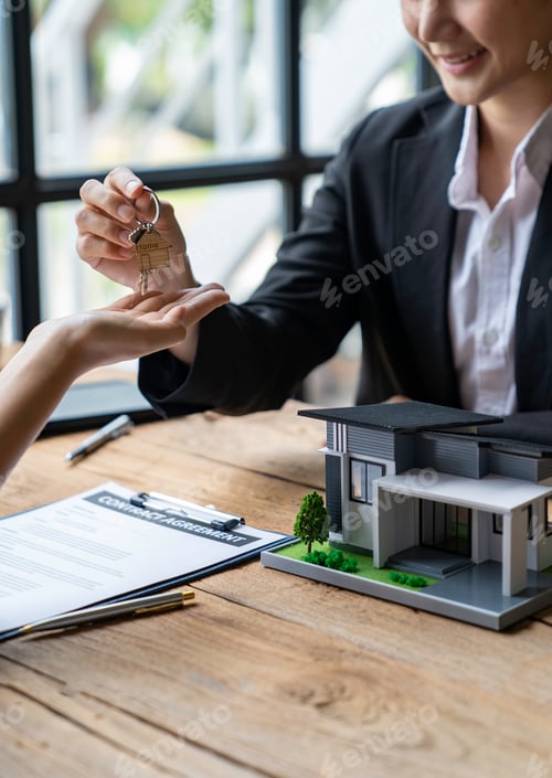 Preview: Cropped image of a real estate agent selling broker holds the keys and the model house is given to t