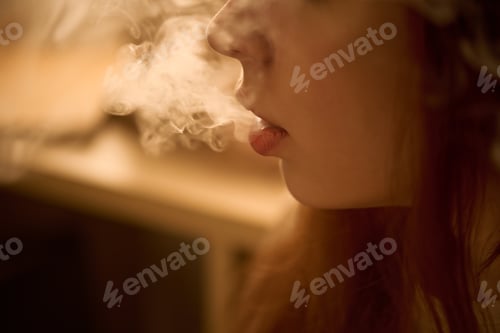 Preview: Young Woman Exhaling Vapor Indoors in Close up Side Profile