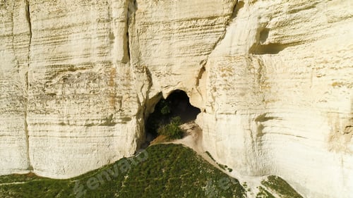 Preview: Aerial for the small cave with growing tree inside, summer landscape. Shot. A cleft in the white
