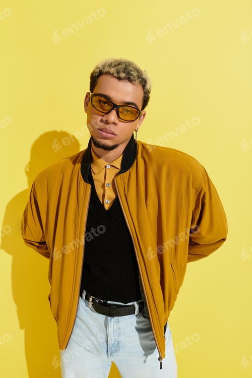 Preview: Stylish young african american man poses confidently in trendy bomber jacket