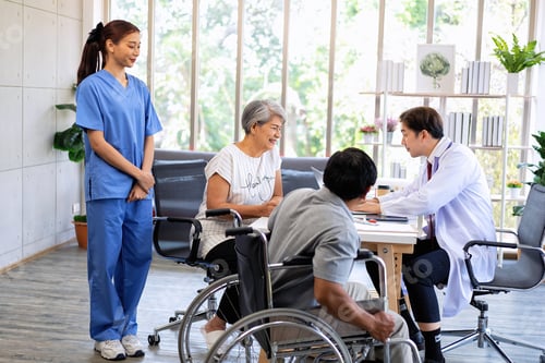 Preview: Senior couple male on wheel chair having consultations with doctor for knee problems at clinic