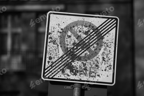 Preview: Close-up, grayscale shot of a dirty traffic signboard with a blurred background