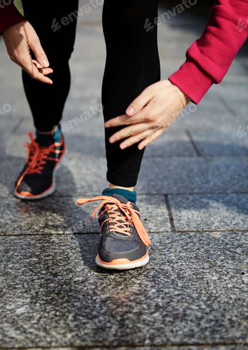 Preview: Legs of woman wearing running shoes on pavement