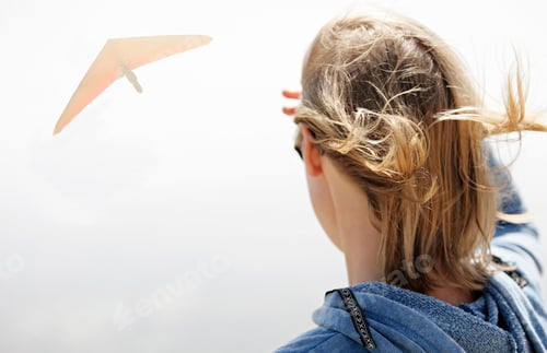 Preview: Woman watching hang glider in sky