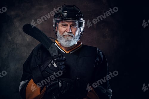 Preview: Elderly sportsman dressed in uniform and helmet holding stick