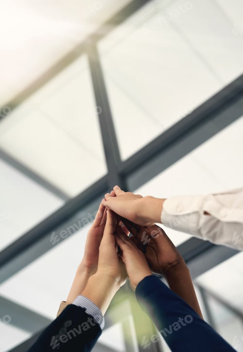 Preview: High five to success. Shot of a group of people putting their hands up together.