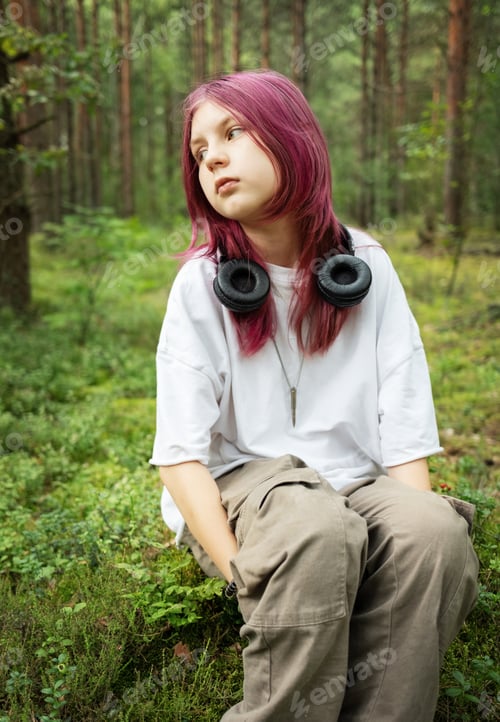 Preview: Youngster with pink hair enjoying nature's sounds in lush forest